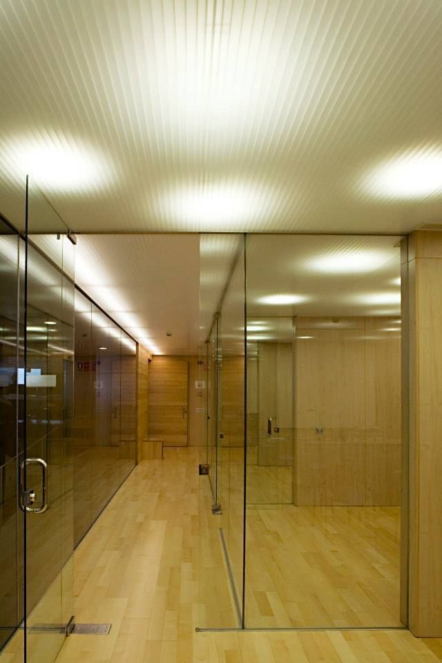 Un pasillo con pisos de madera y puertas de vidrio.