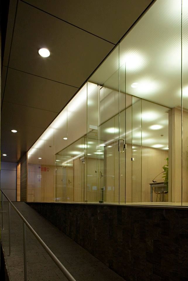 Un edificio con muchas paredes de cristal y una rampa.