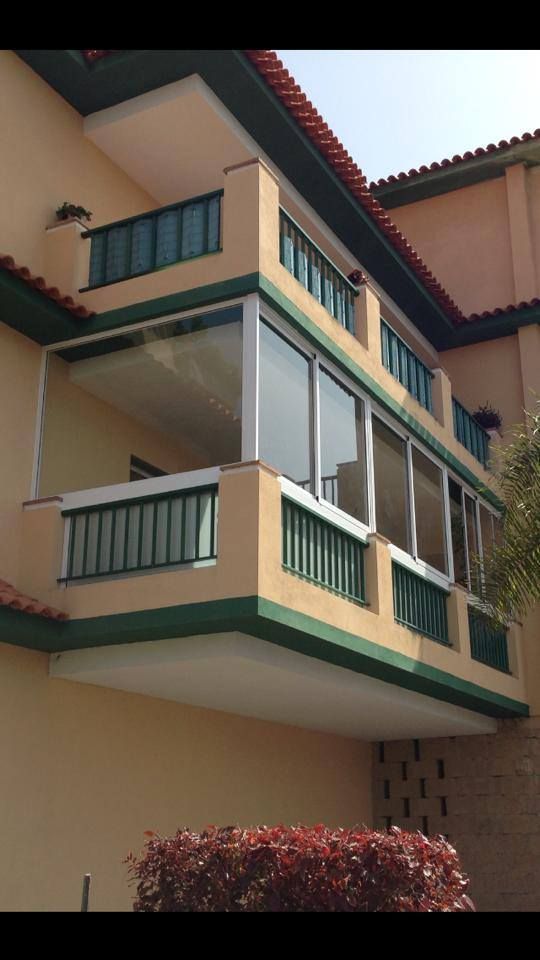 Un balcón en el costado de un edificio con muchas ventanas.