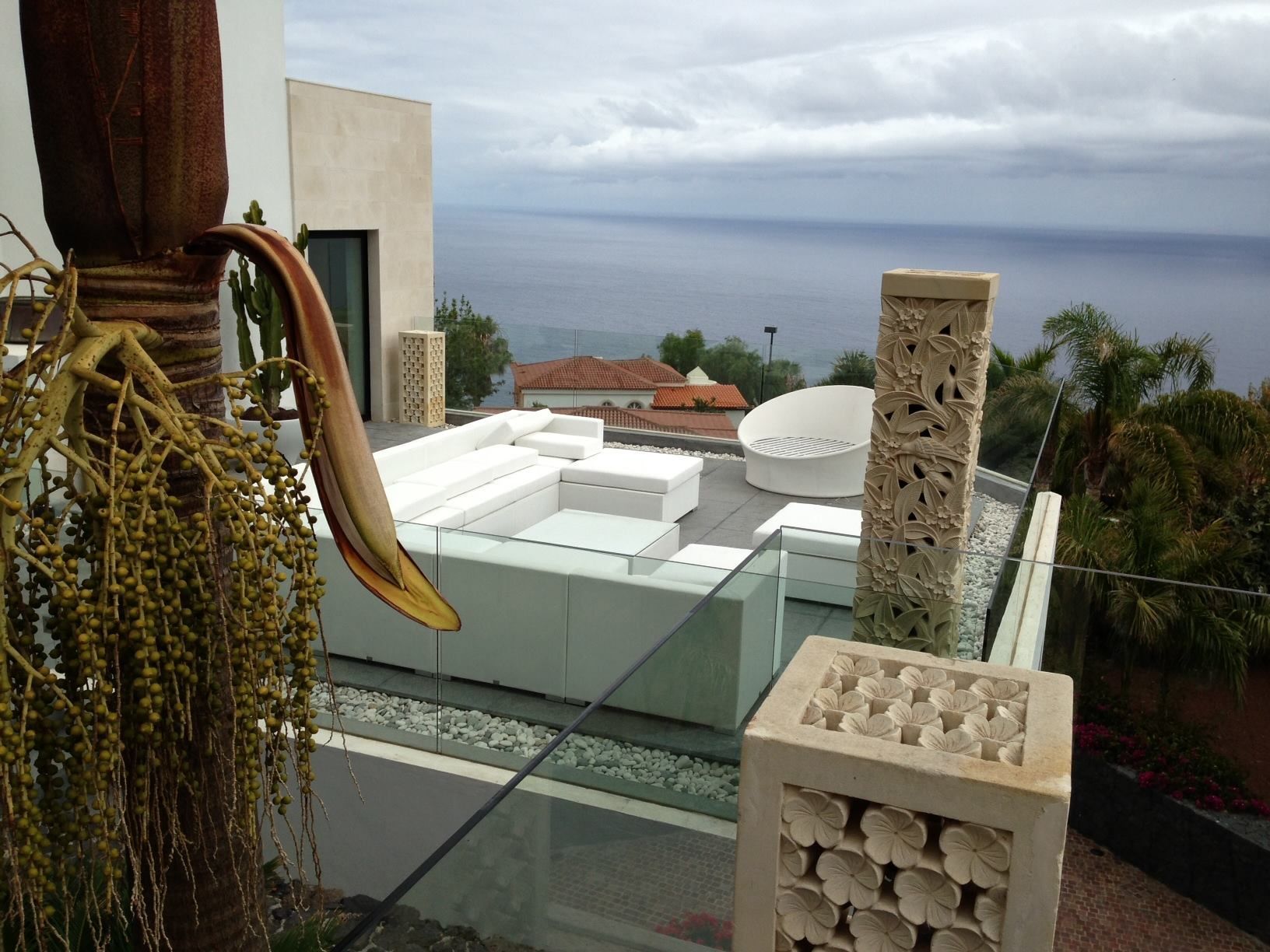 Un balcón con vista al mar y un sofá blanco.