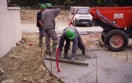 Un grupo de trabajadores de la construcción está trabajando en una acera.