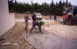 Un grupo de trabajadores de la construcción está trabajando en un camino de entrada de hormigón.