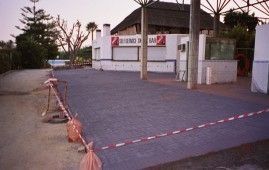 Un edificio con techo de paja está rodeado por una valla.