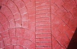 Un primer plano de un piso de ladrillo rojo con un patrón en él.
