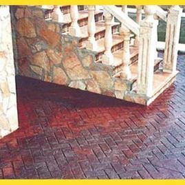 Una escalera con piso de ladrillo y pared de piedra.