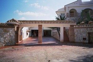 Una gran casa blanca con un gran camino de entrada que conduce a ella.