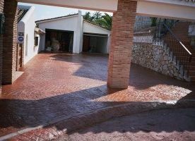Un camino de entrada que conduce a una casa con garaje y escaleras.