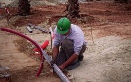 Un hombre que lleva un casco verde está arrodillado en el suelo.