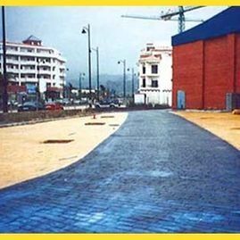 Una imagen de una calle con un edificio al fondo.