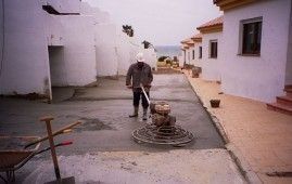 Un hombre está usando una máquina para nivelar un camino de entrada de concreto.
