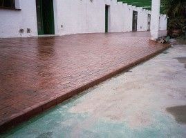 Se está construyendo una pasarela de ladrillos frente a un edificio blanco.
