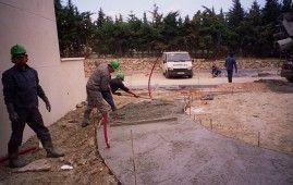 Un grupo de trabajadores de la construcción está trabajando en un camino de entrada de hormigón.