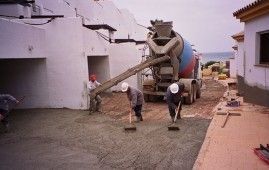 Un camión de hormigón está vertiendo hormigón en un camino de entrada.