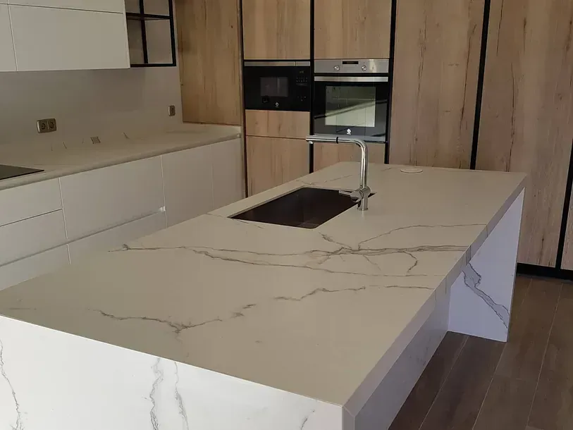Una cocina con una gran encimera de mármol y un fregadero.