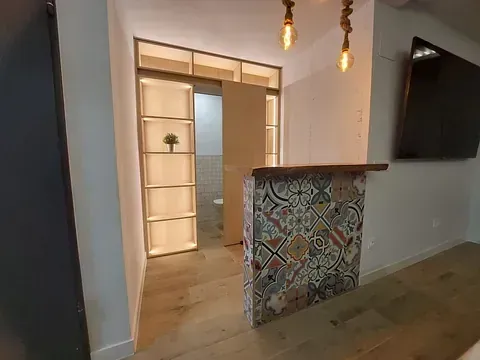 Una sala de estar con una puerta corrediza de vidrio que conduce a un baño.