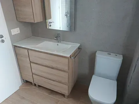 Un baño con lavabo, inodoro y espejo.