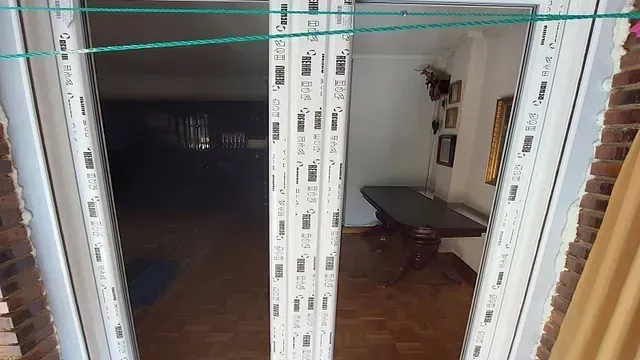 Una habitación con una mesa y una puerta corrediza de vidrio.