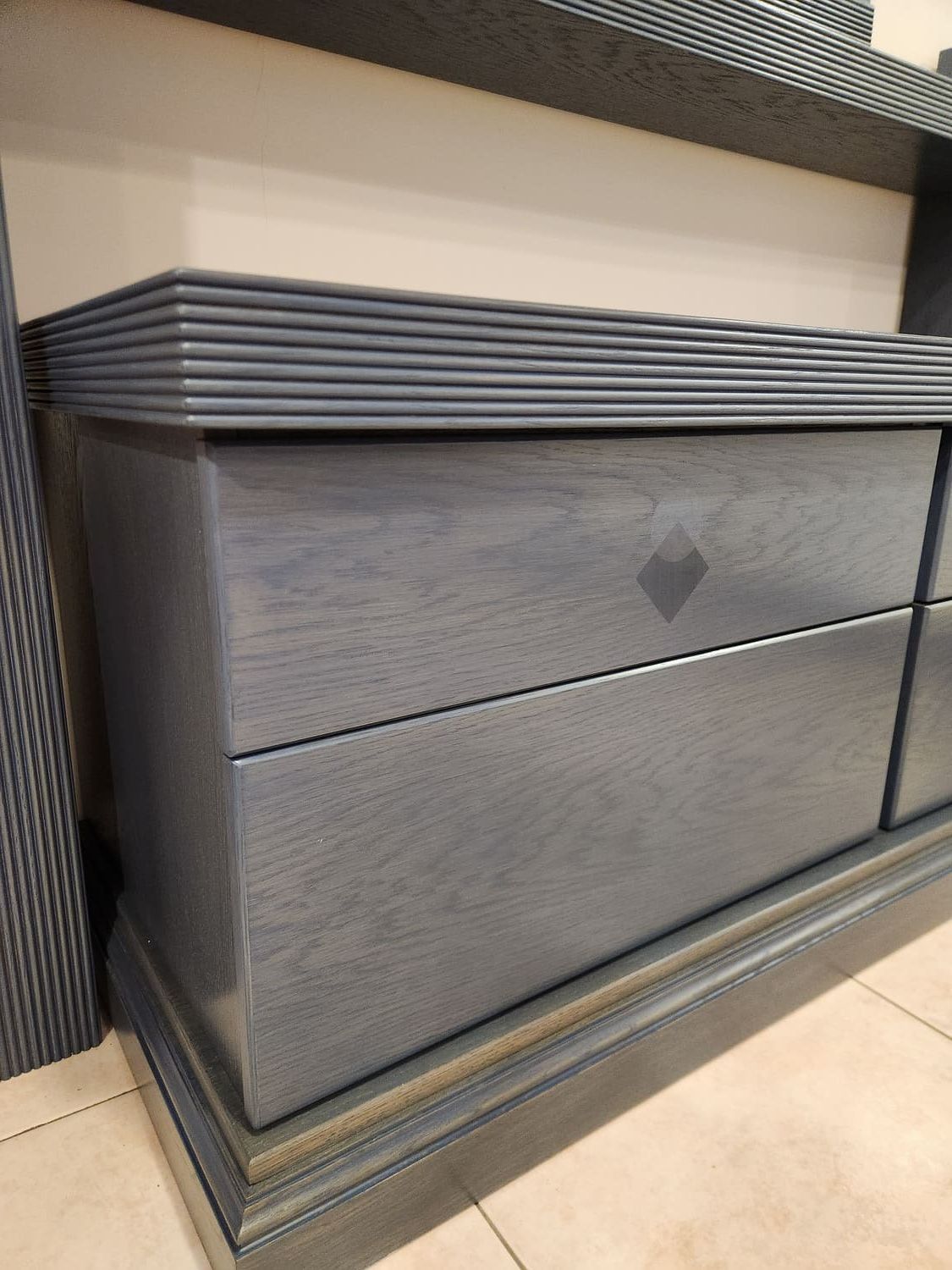 Cómoda azul con tapa geométrica y detalle de rombos en cajón.