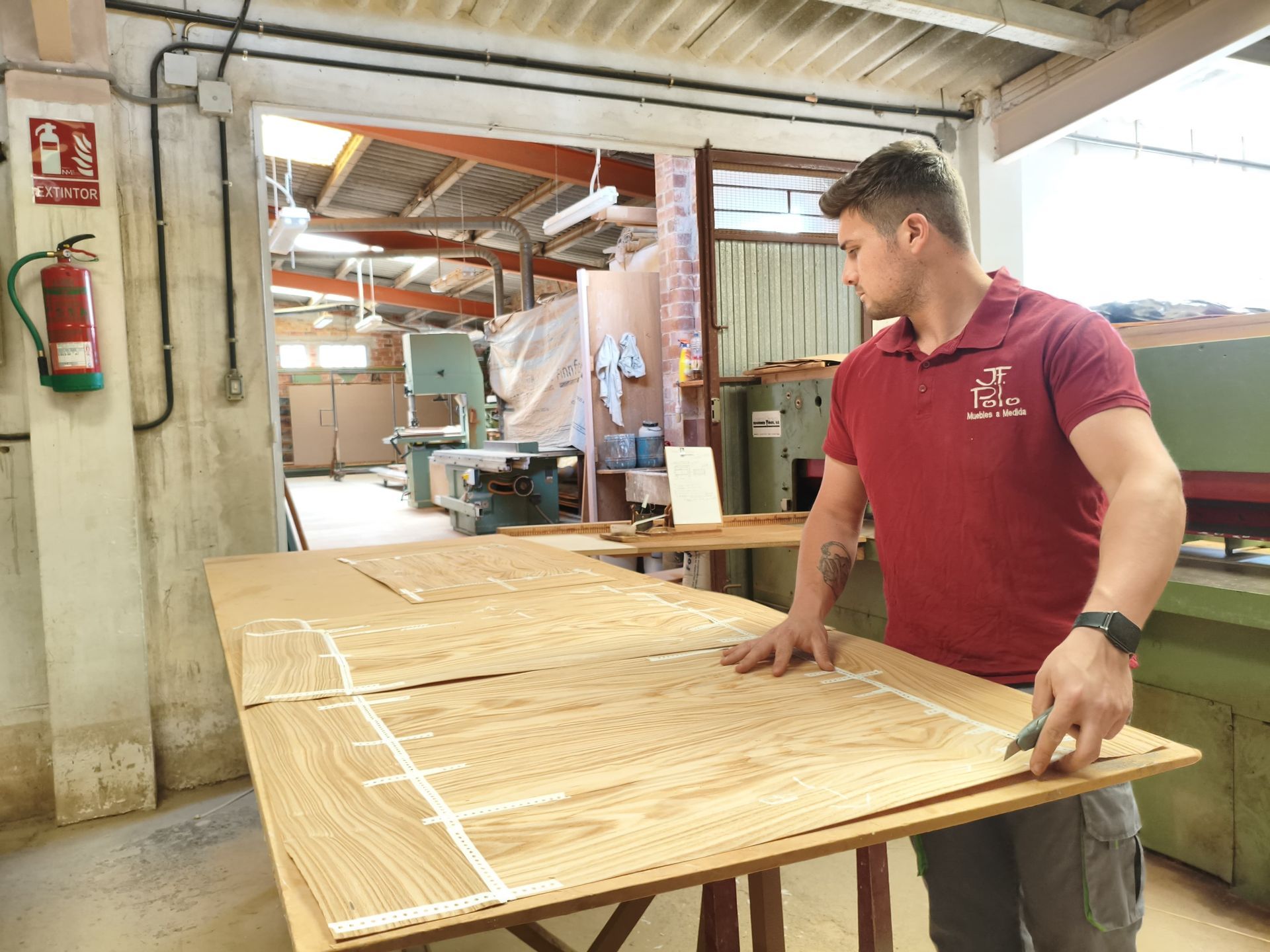 Una persona está midiendo un trozo de madera en una mesa.
