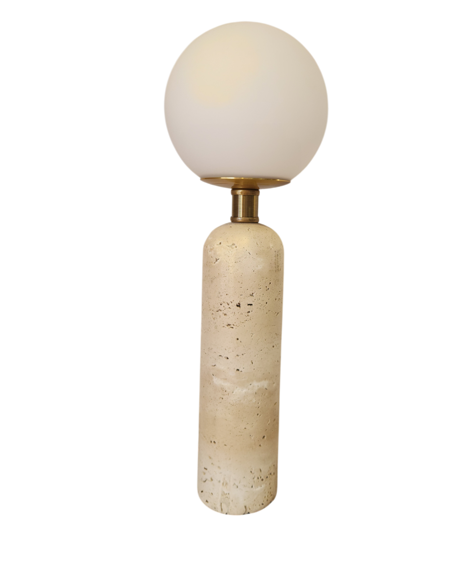 Una lámpara de mesa alta, cilíndrica, de piedra travertino beige, con cuello de latón y bombilla redonda de cristal blanco esmerilado.