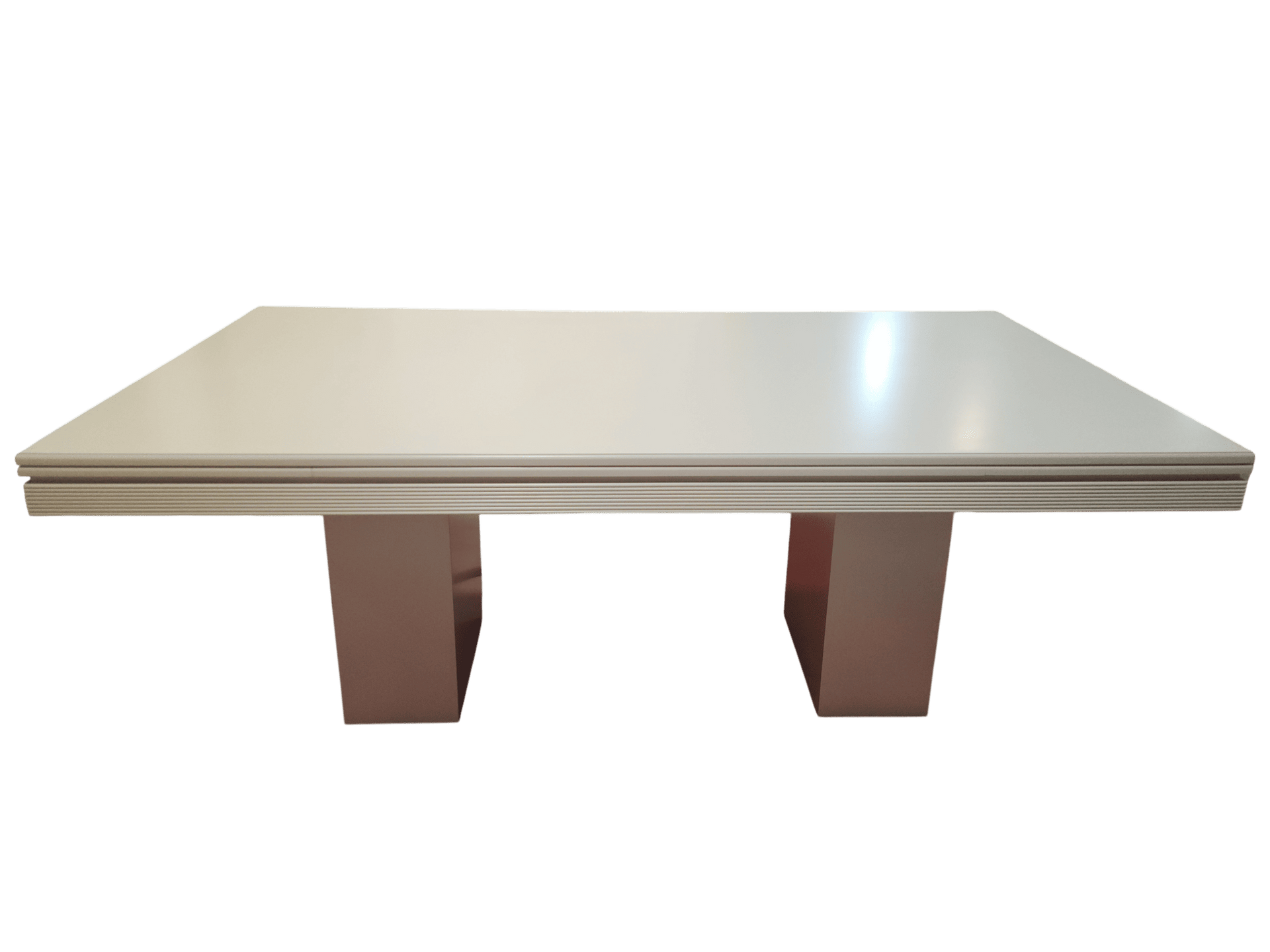 Una mesa rectangular de color beige claro con dos bases de pedestal anchas a juego sobre un fondo blanco.