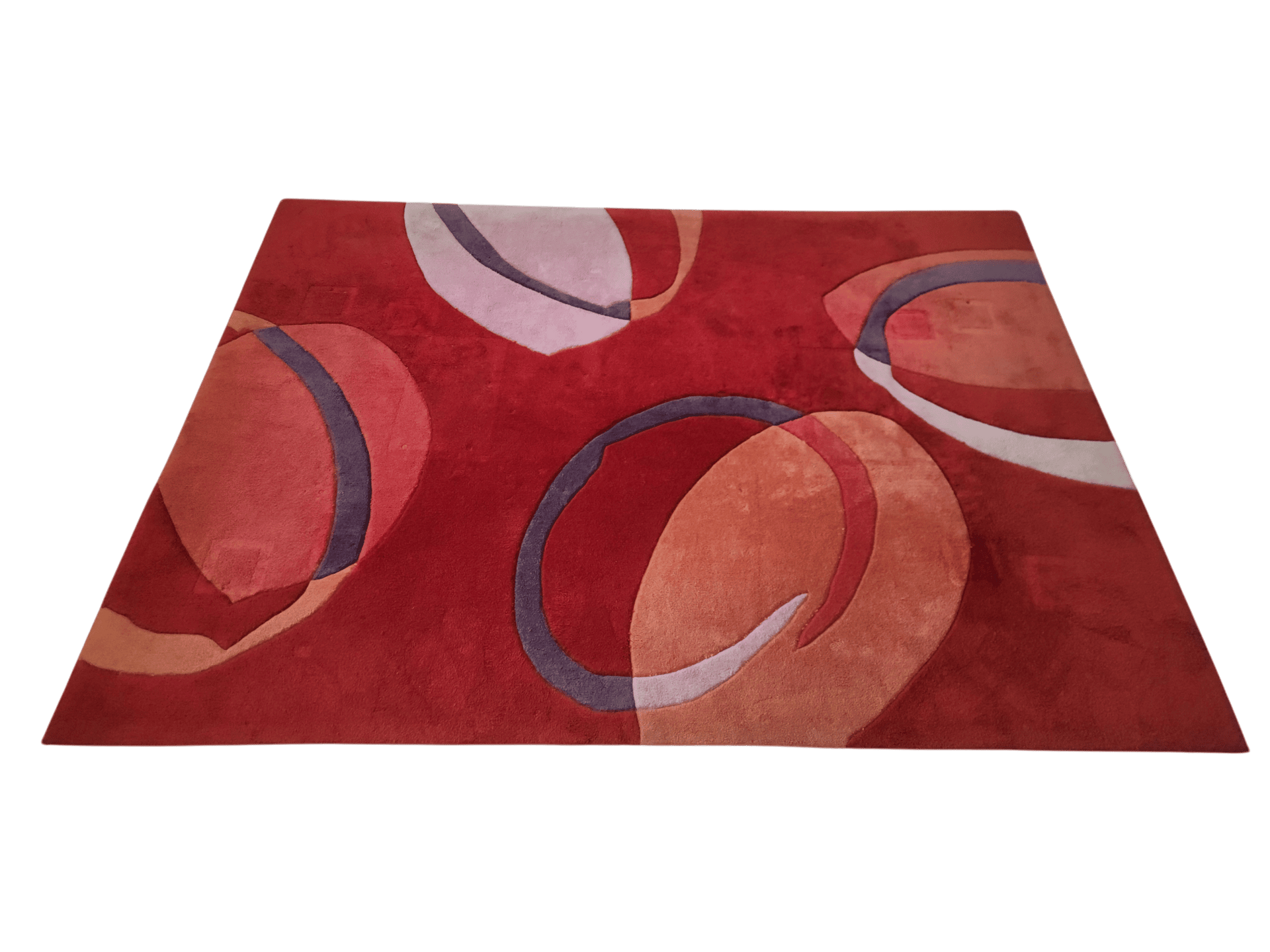 Una alfombra rectangular roja con formas circulares abstractas en tonos naranja, rosa claro y gris oscuro.