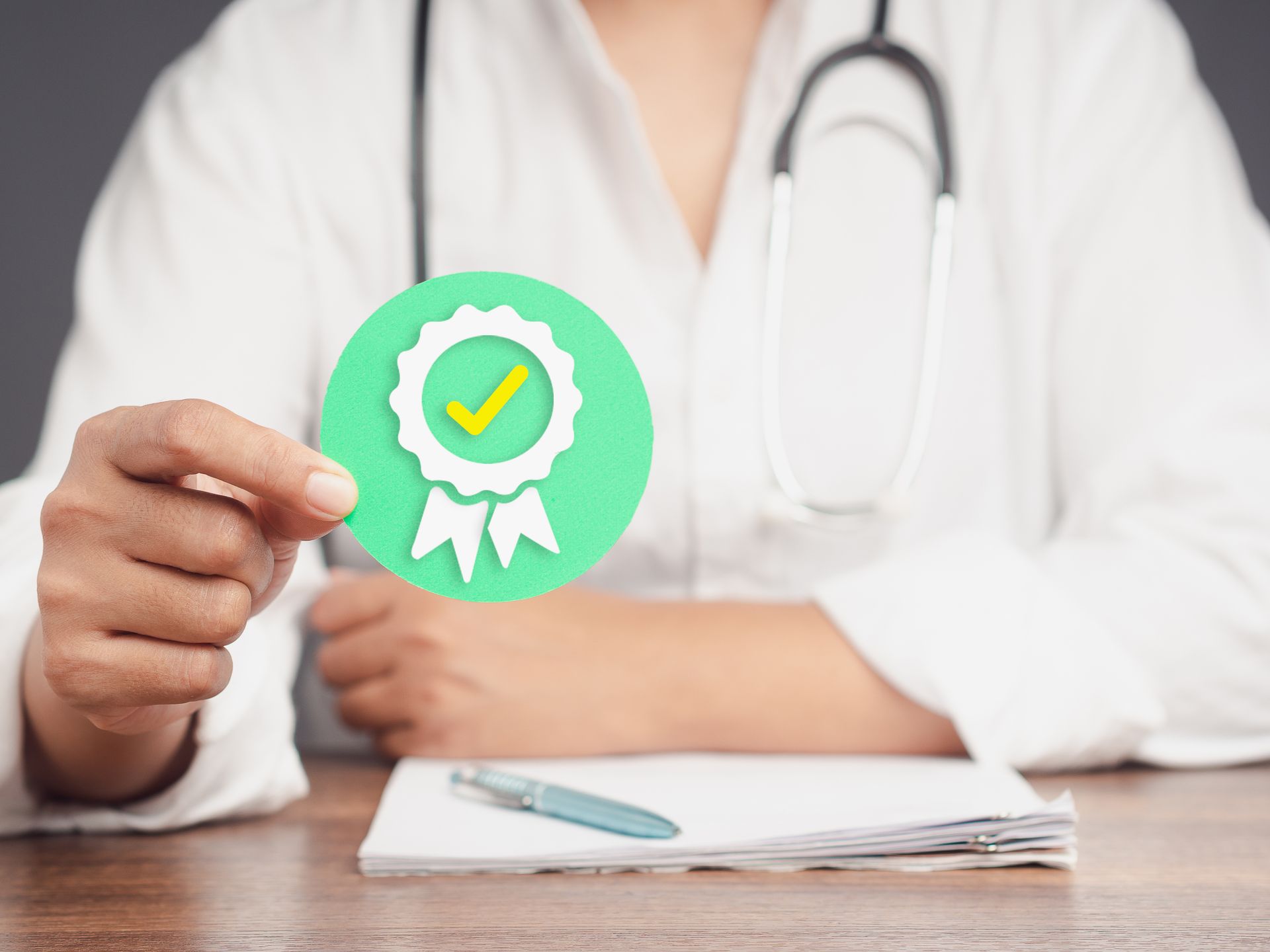 Un médecin tient un macaron certification