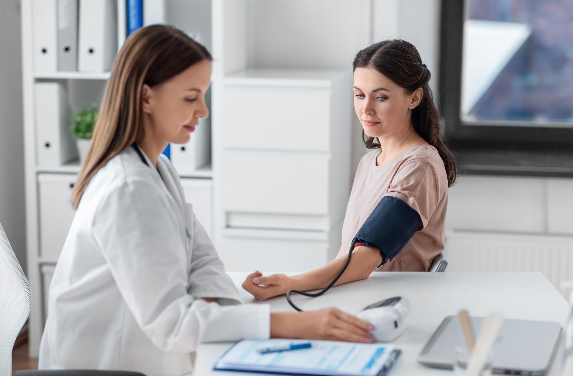 Un médecin prend la tension d'une patiente
