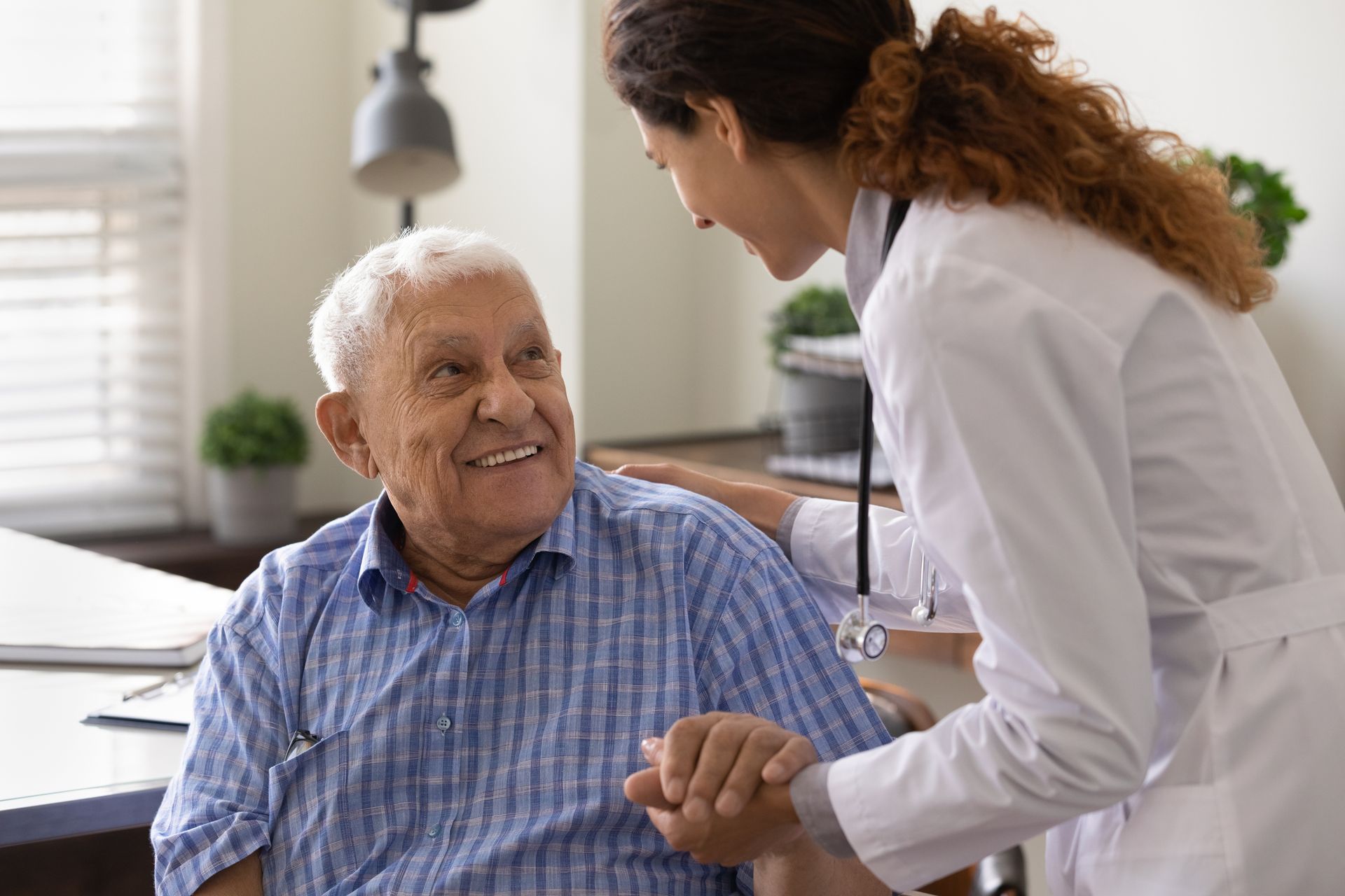 Un homme âgé souriant parle avec une médecin