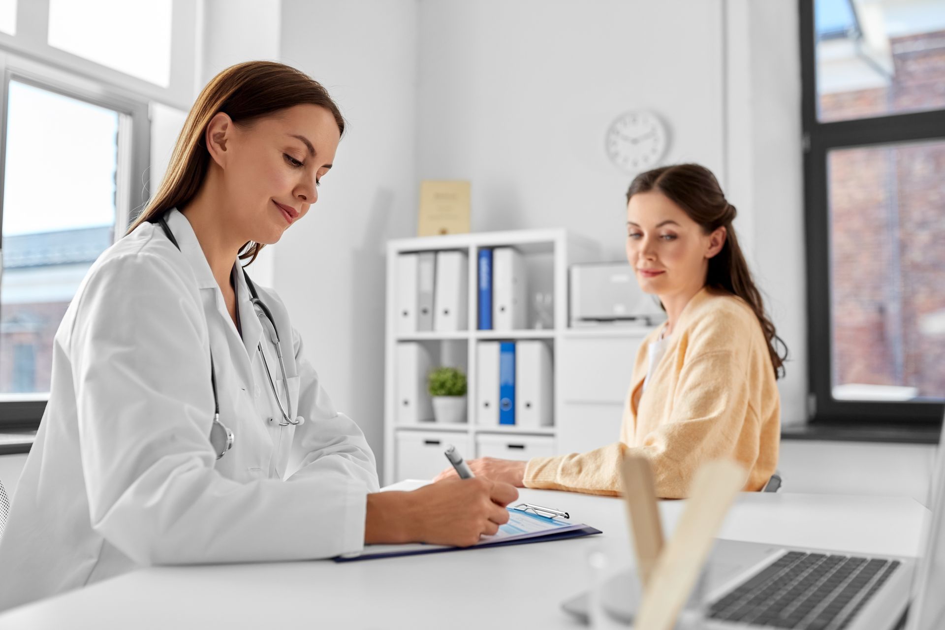 Un médecin en consultation rédige une ordonnance