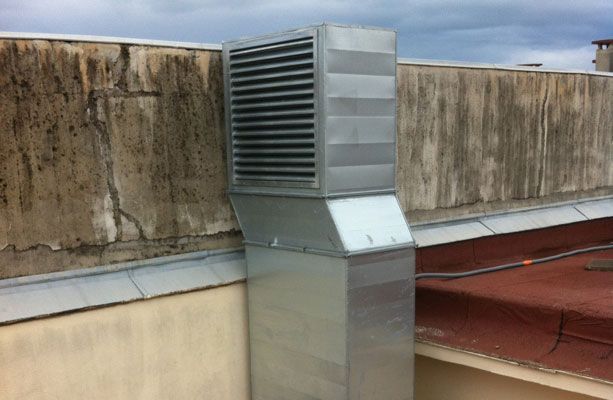 Un conduit de ventilation métallique sur le toit d'un bâtiment.