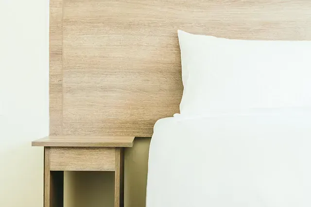 Acogedora sala de estar con paredes beige, sofá, sillones, plantas y detalles tejidos.