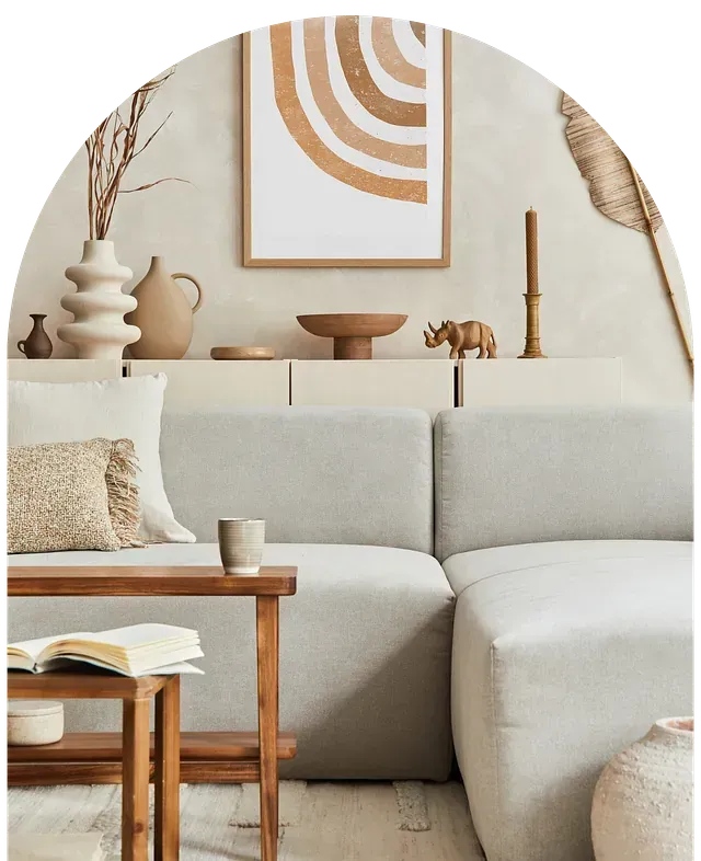 Sala de estar en tonos neutros con sofá seccional, muebles de madera, decoración y obras de arte.