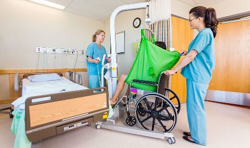 Deux soignantes avec un patient en chaise roulante