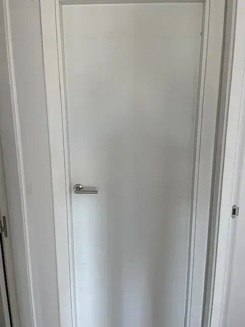 Un primer plano de una puerta blanca en un pasillo.