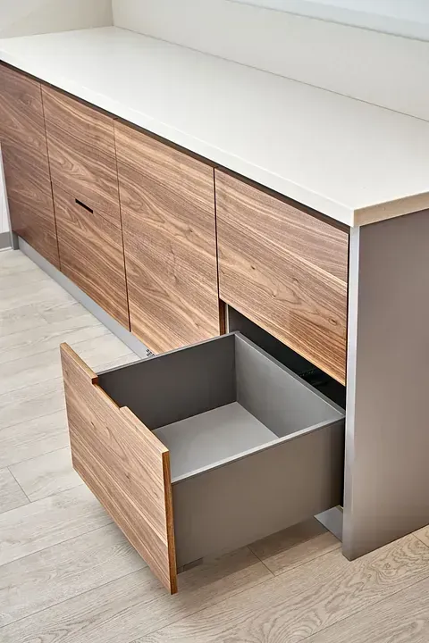 Un armario de madera con un cajón abierto en una cocina.