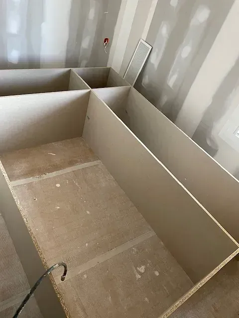 Una habitación con muchos estantes vacíos y un espejo en la pared.