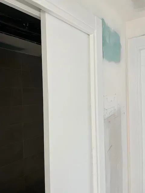 Se está instalando una puerta corrediza blanca en una habitación.