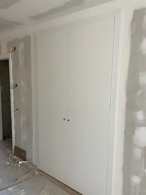 Una habitación con un armario y una puerta.