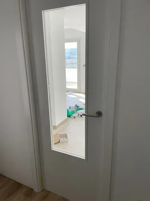 Una puerta blanca con una ventana de vidrio en una habitación.