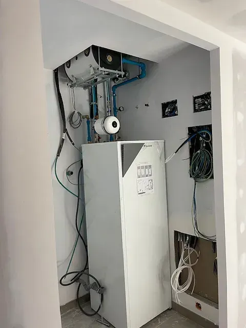 Hay una caja blanca en una habitación con muchos cables saliendo de ella.