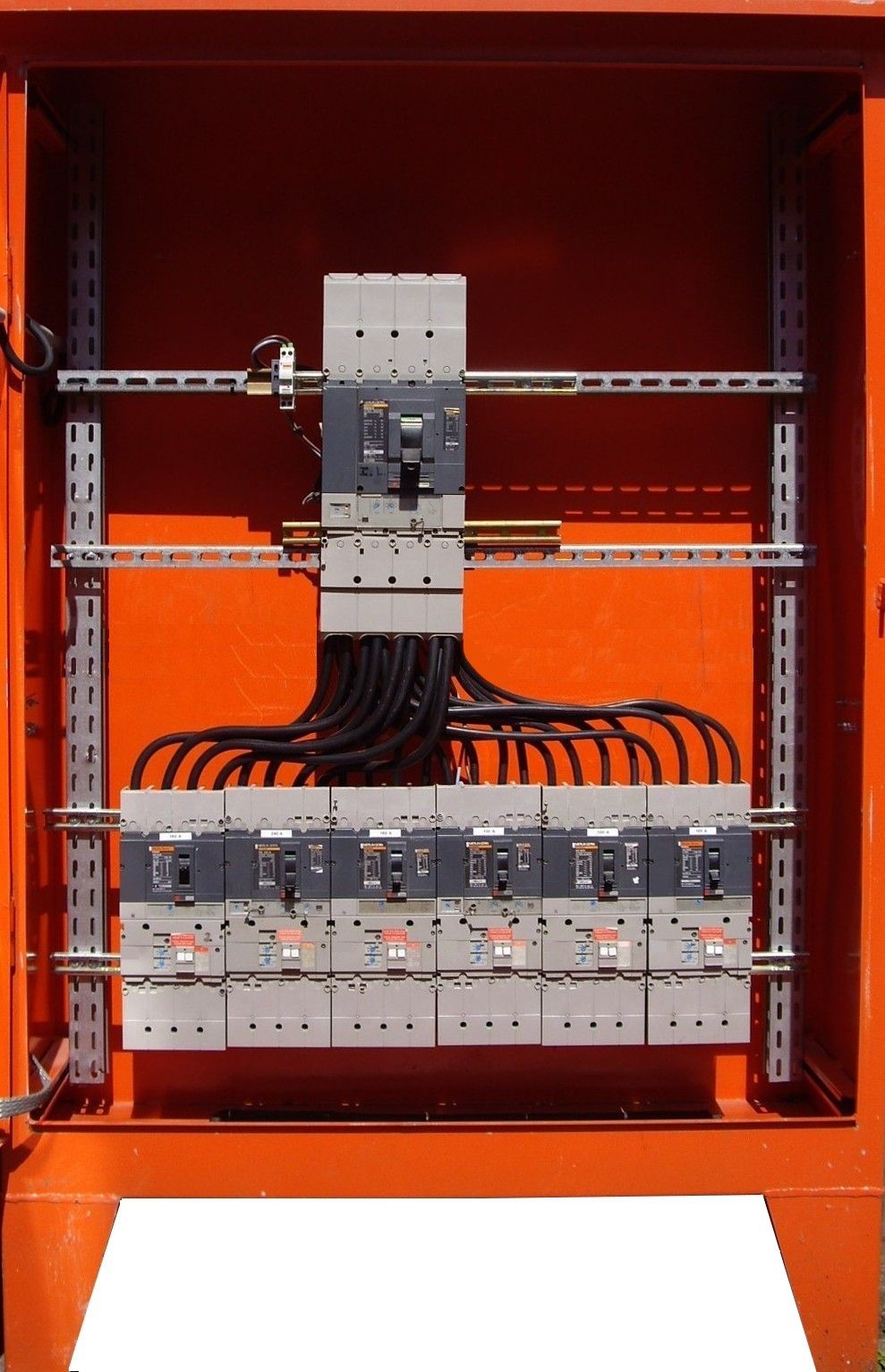 Armoire électrique orange avec disjoncteurs et câblage.
