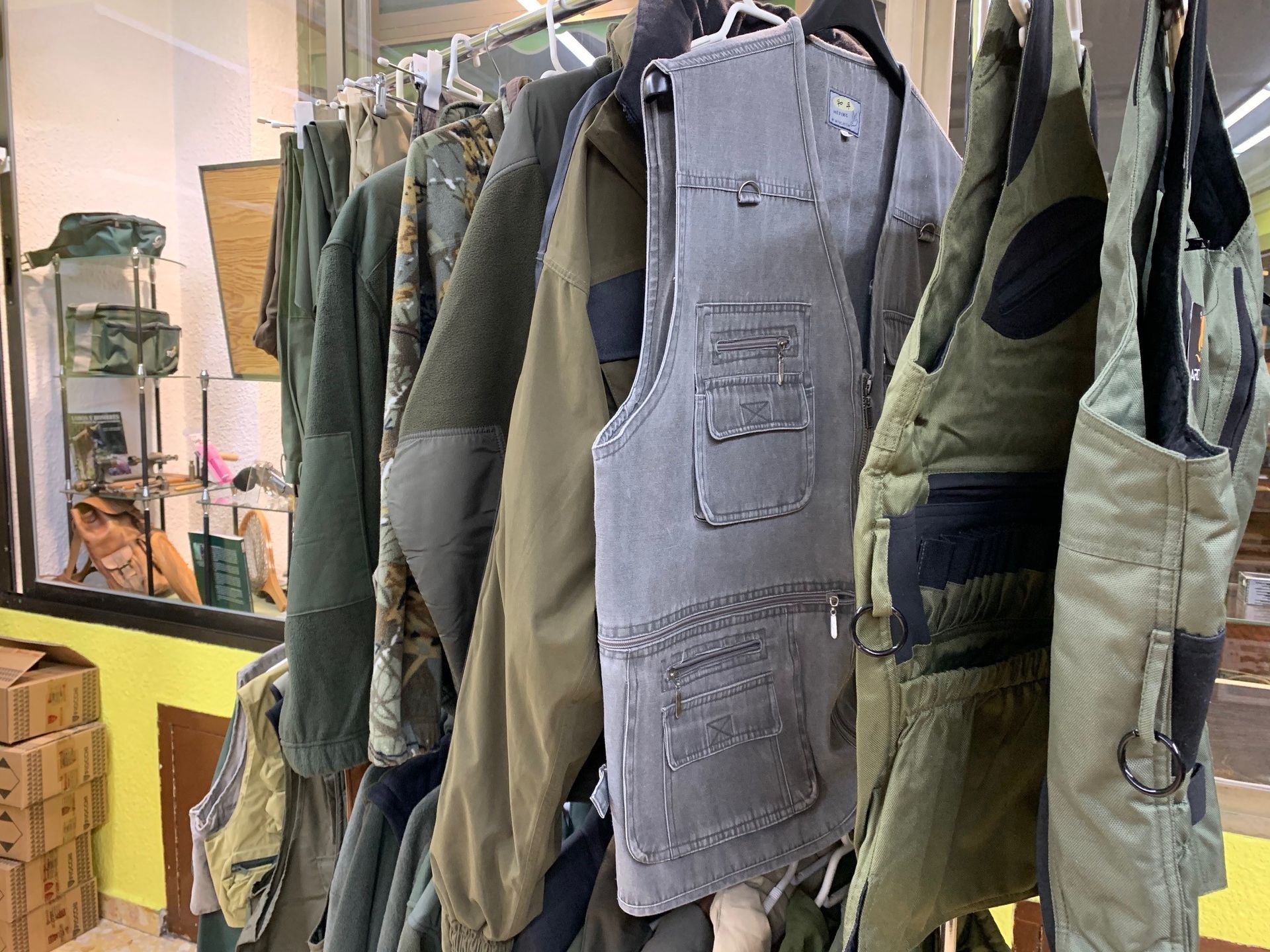 Un montón de chaquetas y chalecos están colgados en un perchero.