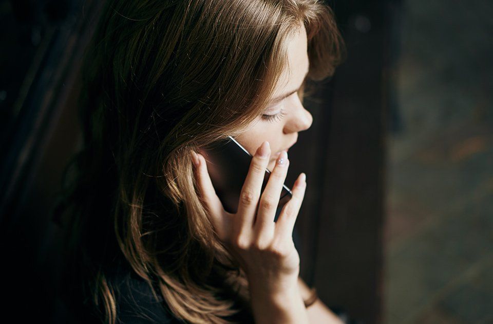 Junge Frau mit einem Handy am Ohr