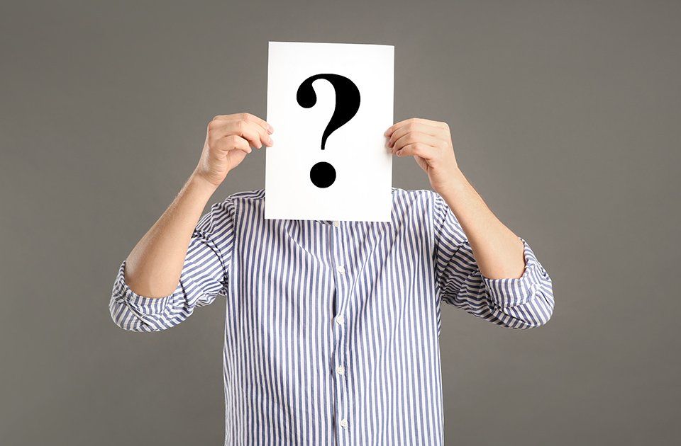 Person mit einem Fragezeichen vorm Gesicht