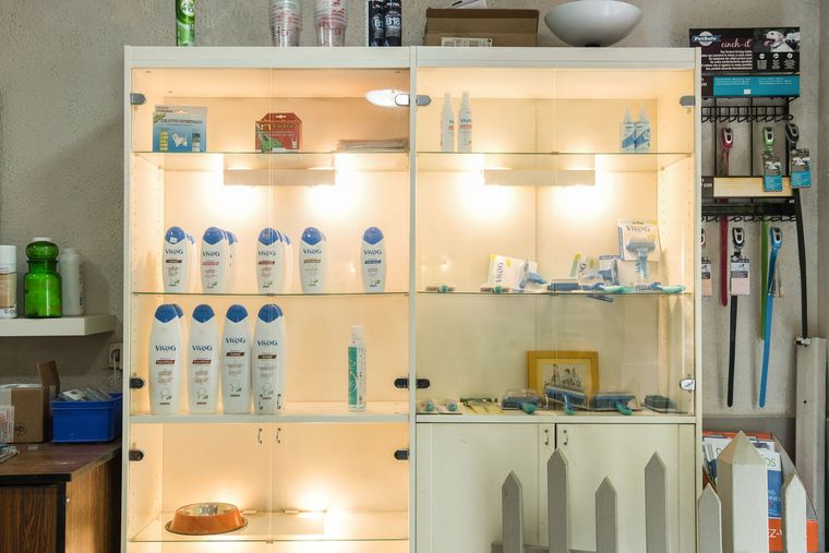 Étagères de salle de bains rétroéclairées avec des rangées de flacons blancs et de produits de soins.