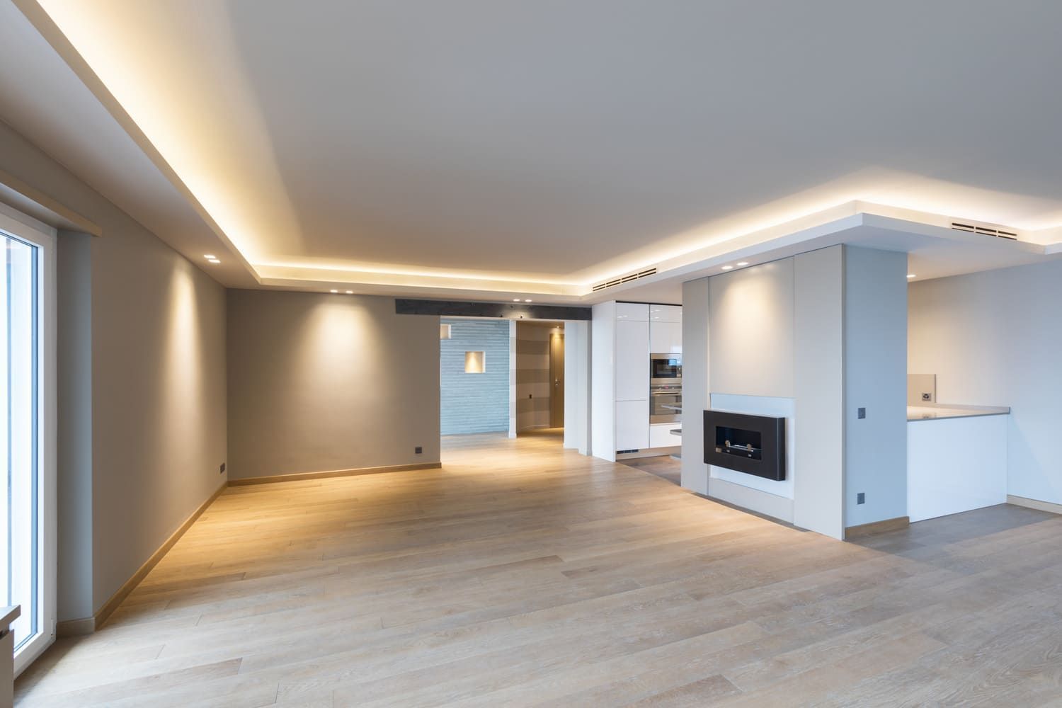 Una sala de estar vacía con pisos de madera y chimenea.