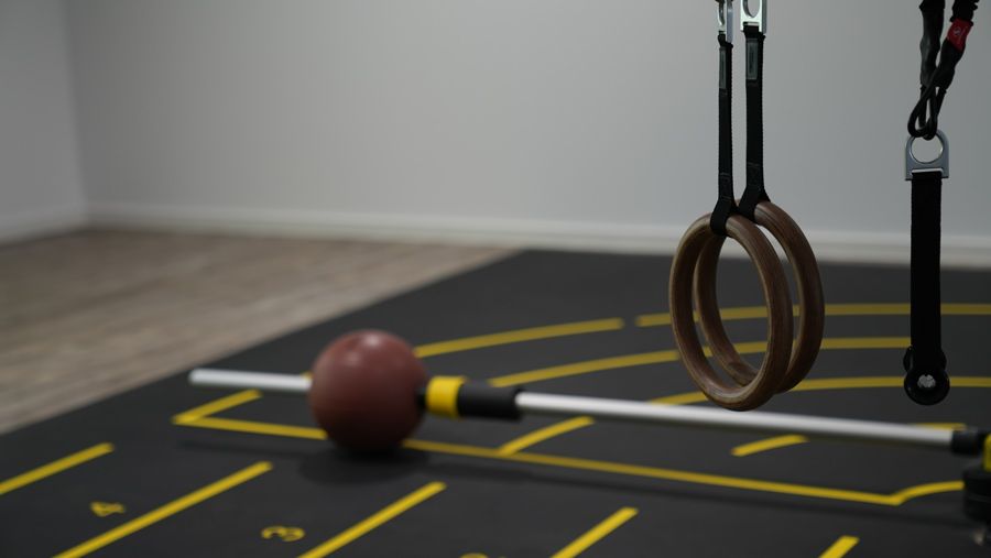 Ein Turnhallenboden mit einem Ball und Ringen darauf.