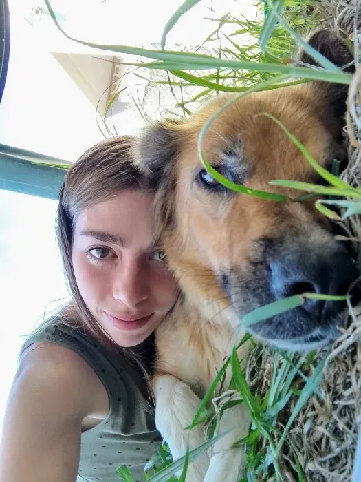 Una mujer se toma un selfie con su perro en el césped.