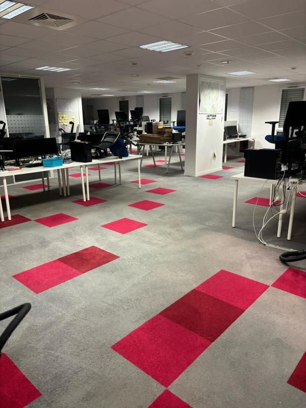Plusieurs bureaux avec ordinateurs dans un open space